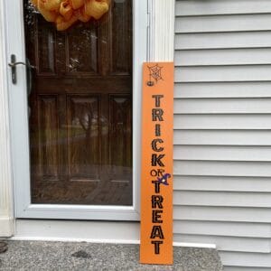 Outdoor Halloween leaning sign. Trick or Treat with spider, web, and witches hat.