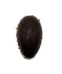 Dark chocolate Easter egg with a geometric tile pattern and colorful sprinkles along the edge.