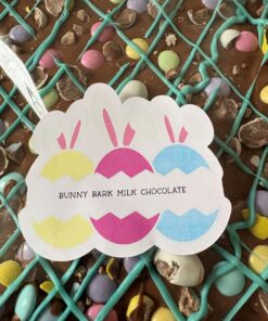 Milk chocolate bark with turquoise lattice drizzle and pastel candy eggs; label reads 'Bunny Bark Milk Chocolate'.